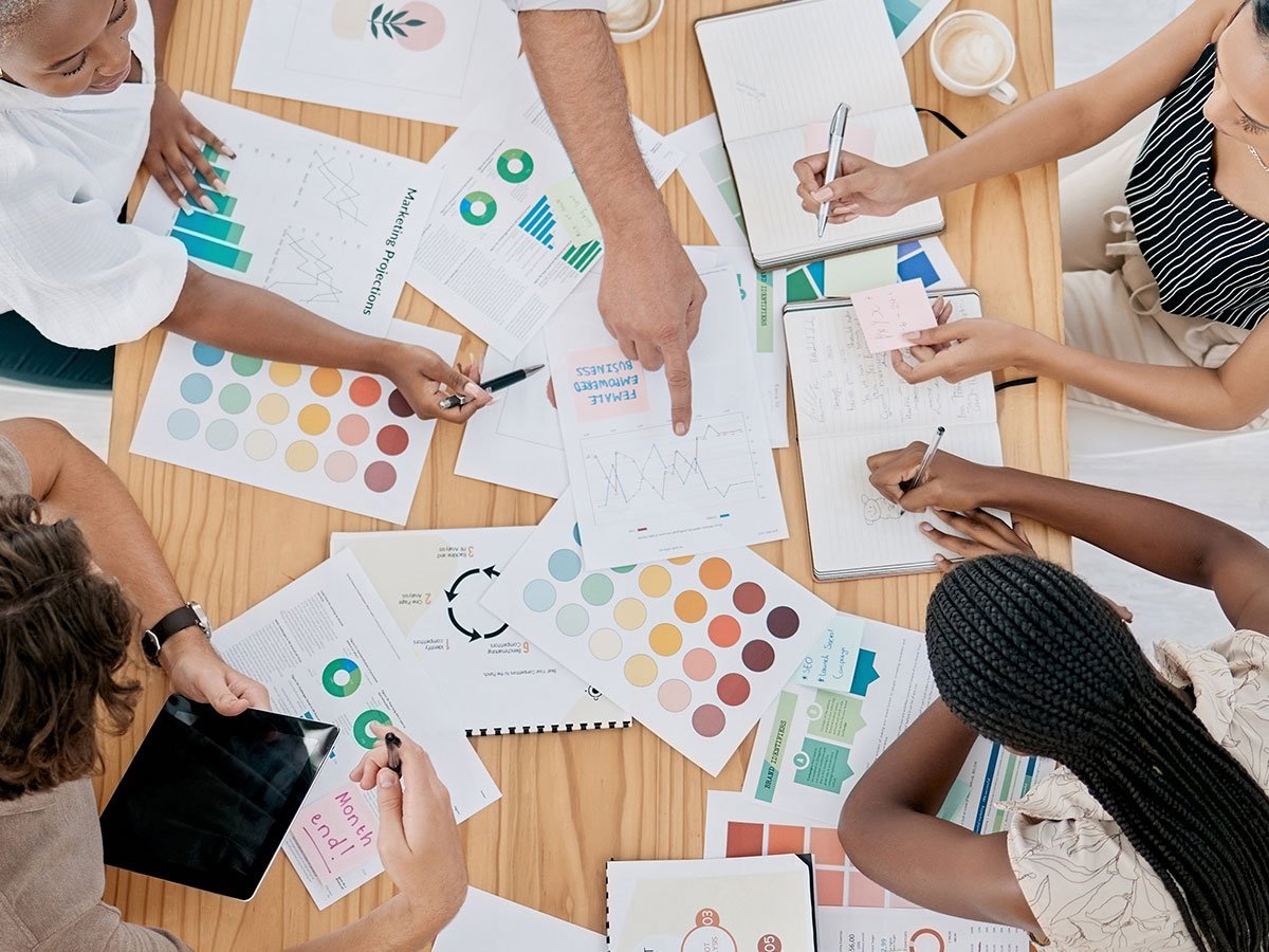 Photo of designers working over color palettes at a table.